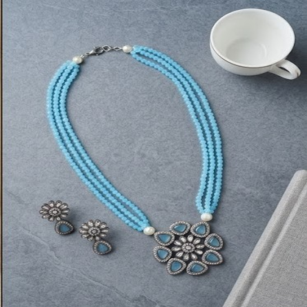 DIVYORO TRIPLE-STRAND BLUE BEAD NECKLACE WITH FLORAL PENDANT